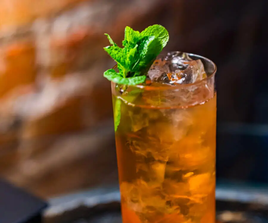 Un grand cocktail de Spritz Tonic rempli de glace et de feuilles de menthe