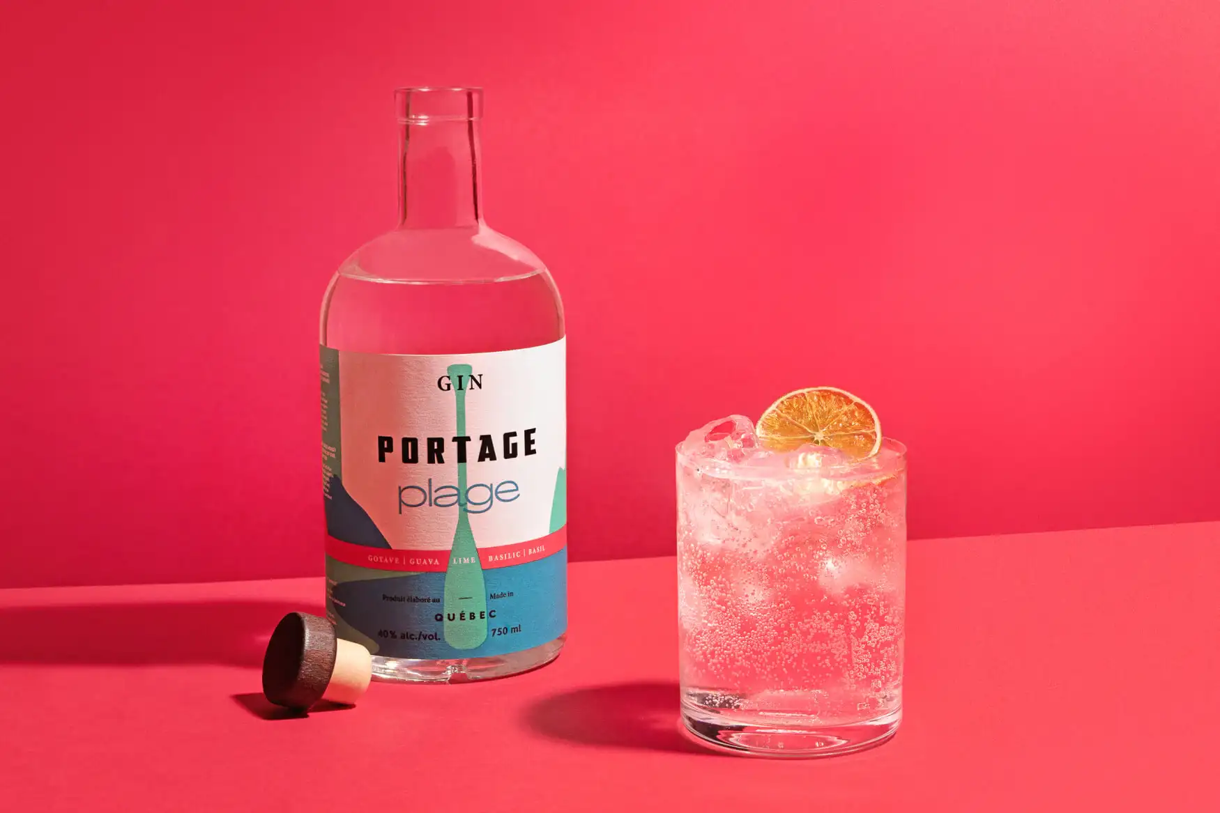 Bouteille de Gin Portage Plage et un cocktail sur fond rouge